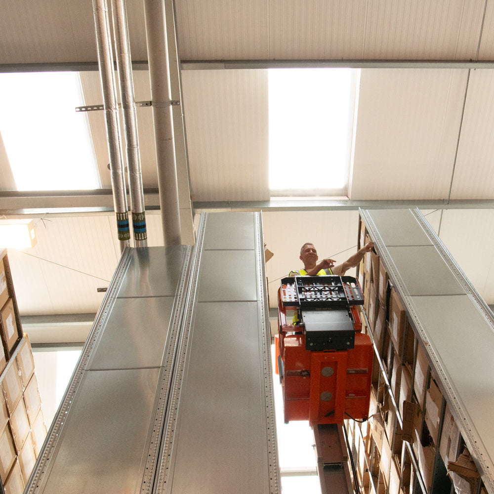 Team Member Using Heavy Duty Lifting Order Picker in UK Fulfilment Centre