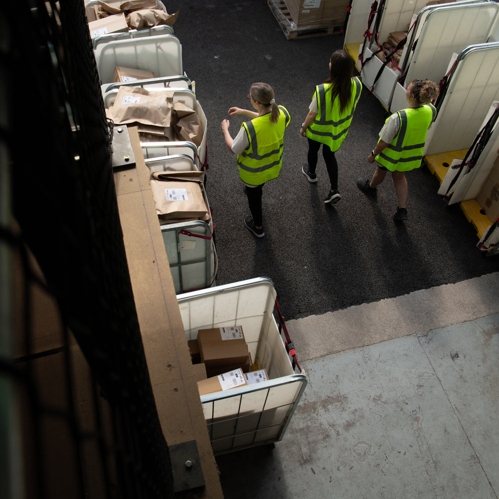 Rocket Team Members Leaving Warehouse Surround by Cages of Parcels Ready to be Dispatched.